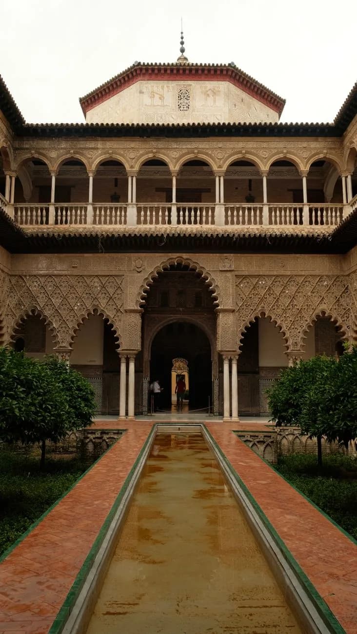 Le patio des Demoiselles de l'Alcázar de Séville, son bassin central, ses arcades mudéjares et sa galerie Renaissance