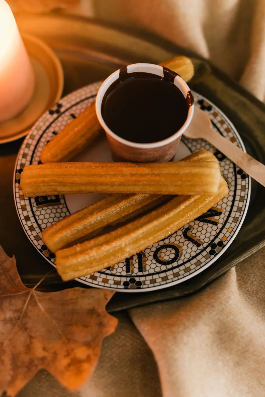 Une assiette de churros et une tasse de chocolat chaud épais