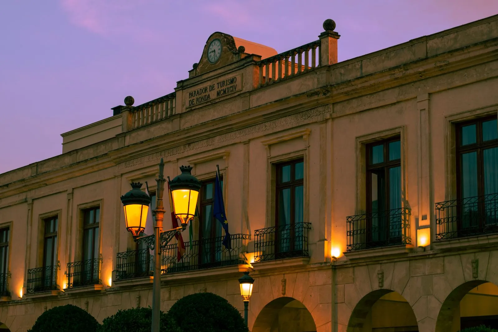 La façade du parador de Ronda au crépuscule, au bord de la gorge du Tajo