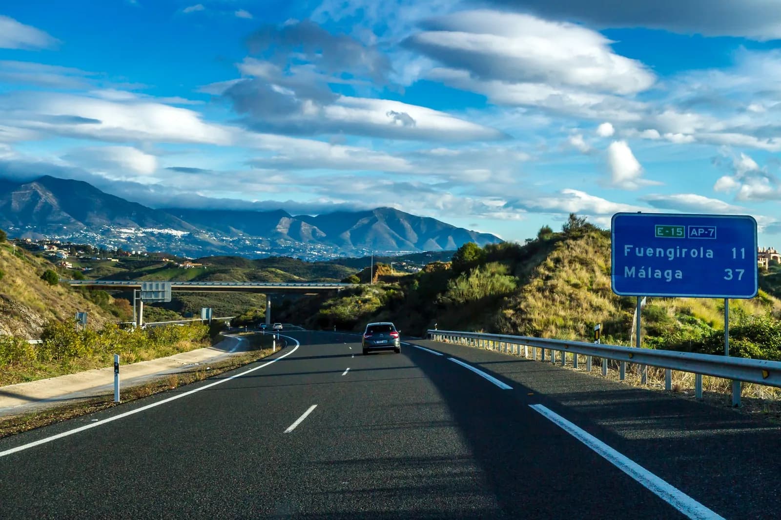 Autovía près de Fuengirola, panneau bleu indiquant Fuengirola 11 et Málaga 37, montagnes de la Costa del Sol au fond