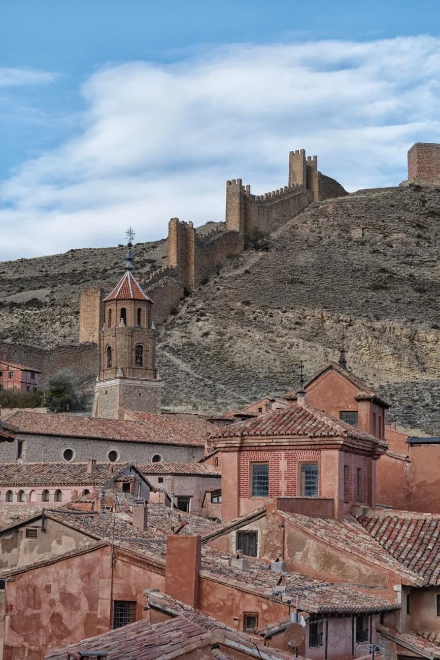 Les toits roses d'Albarracín dans la province de Teruel, dominés par la muraille qui grimpe sur la crête