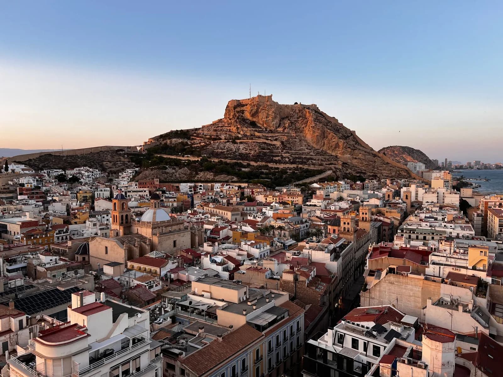 Le château de Santa Bárbara sur le mont Benacantil, dominant les toits du centre d'Alicante au coucher du soleil
