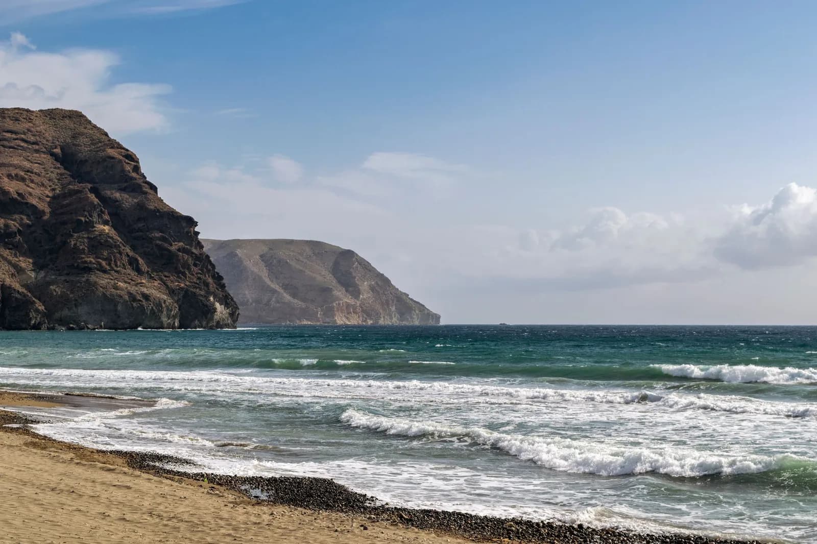 Une plage déserte du cap de Gata en Almérie, dominée par des reliefs volcaniques arides