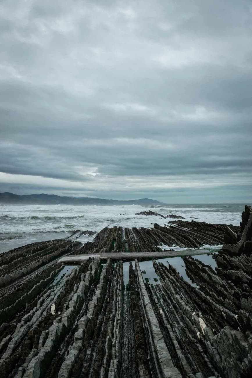 Le flysch de Zumaia sur la côte basque, ses strates rocheuses inclinées peignées vers la mer à marée basse