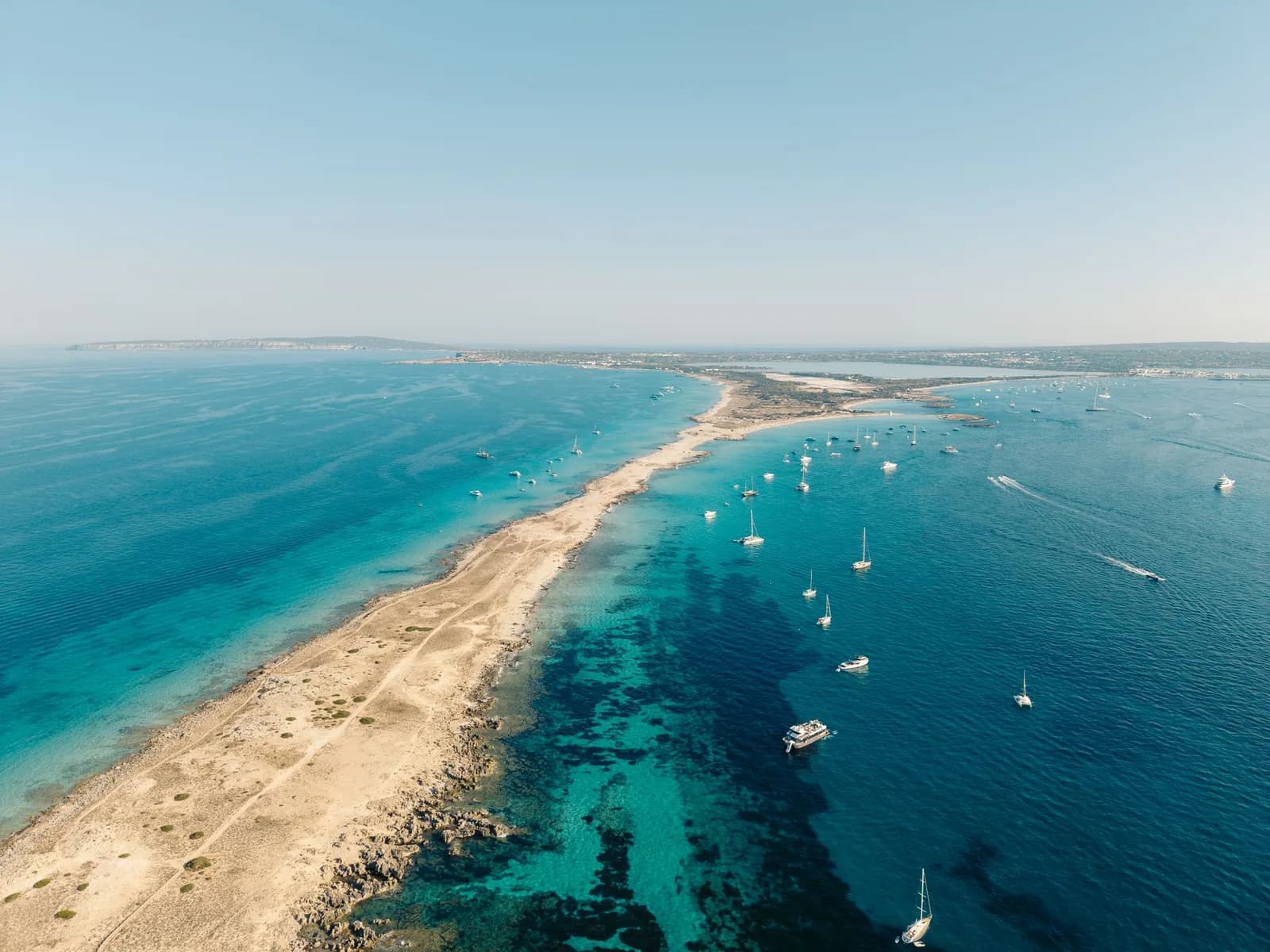 La langue de sable de Ses Illetes à Formentera vue d'en haut, bordée d'eau turquoise et de voiliers