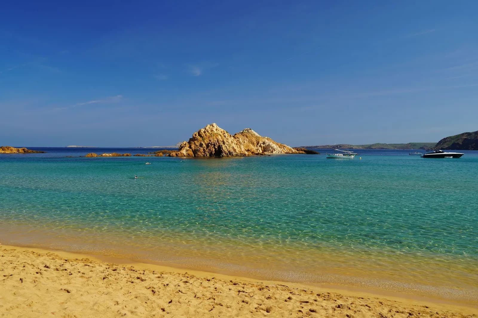 Plage de sable et îlot rocheux sur la côte nord de Minorque