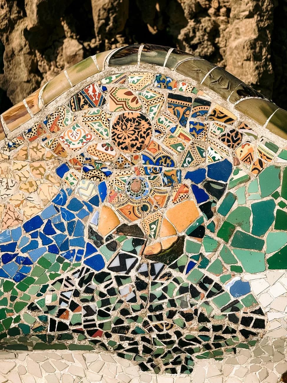 Un détail de trencadís du Park Güell à Barcelone, mosaïque de fragments de céramique cassée aux motifs bleus et verts
