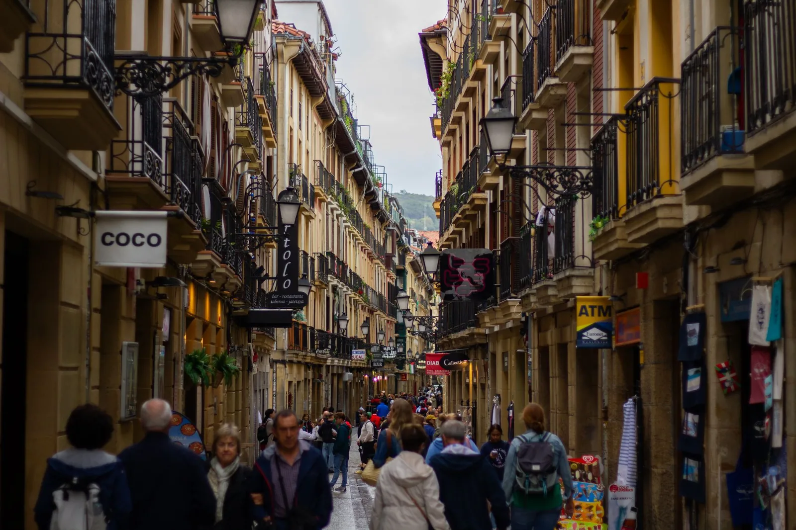 Une ruelle piétonne bondée de la Parte Vieja de San Sebastián, ses balcons de fer forgé et ses enseignes de bars