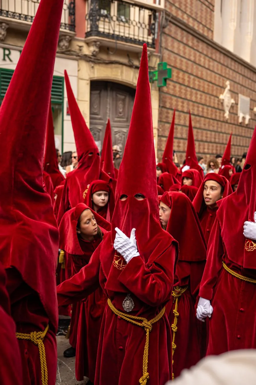 Des pénitents en tunique rouge et capirote pointu lors d'une procession de Semaine sainte en Andalousie