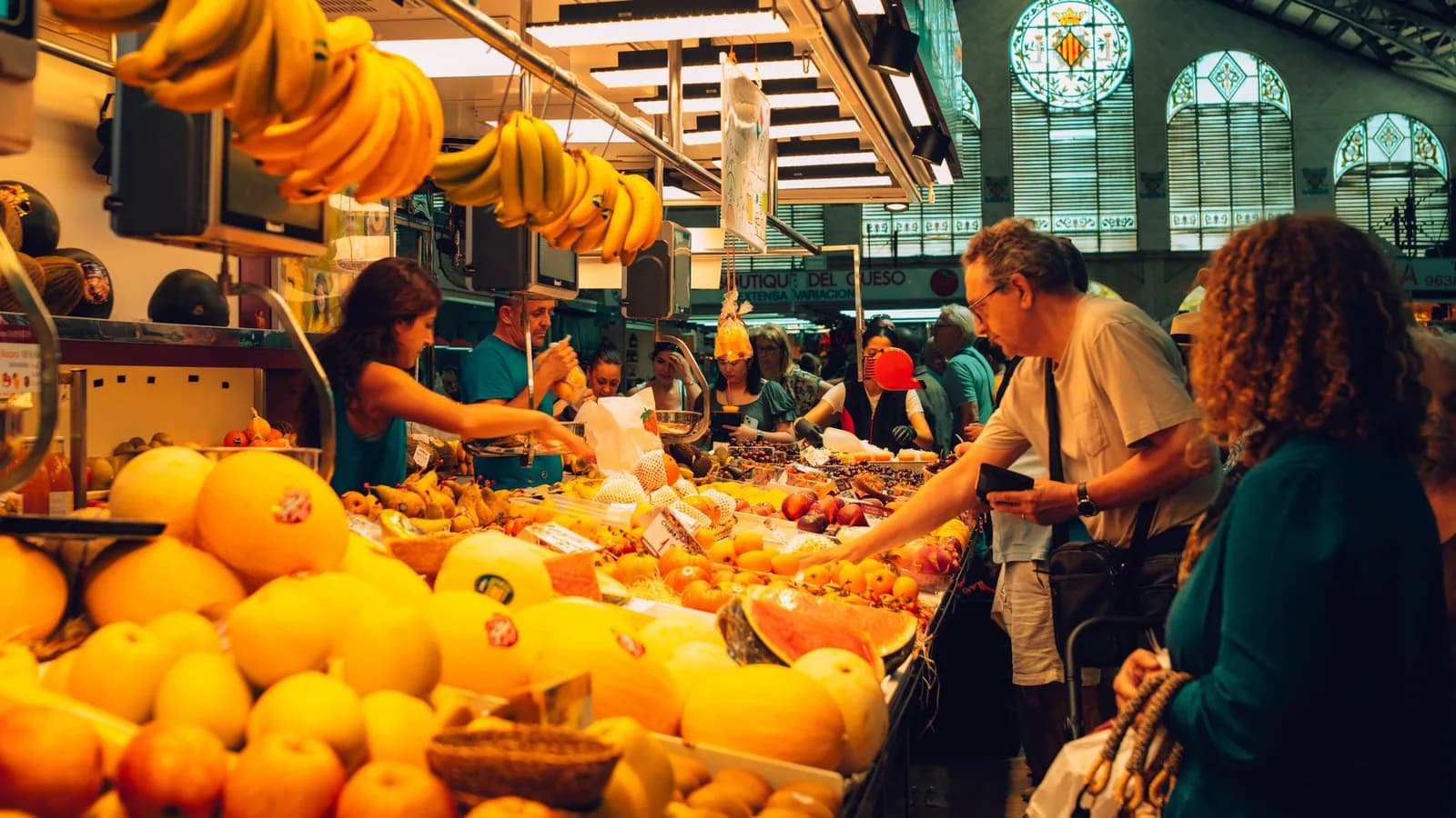 Les étals de fruits du Mercado Central de Valence sous la verrière moderniste et les vitraux au blason de la ville