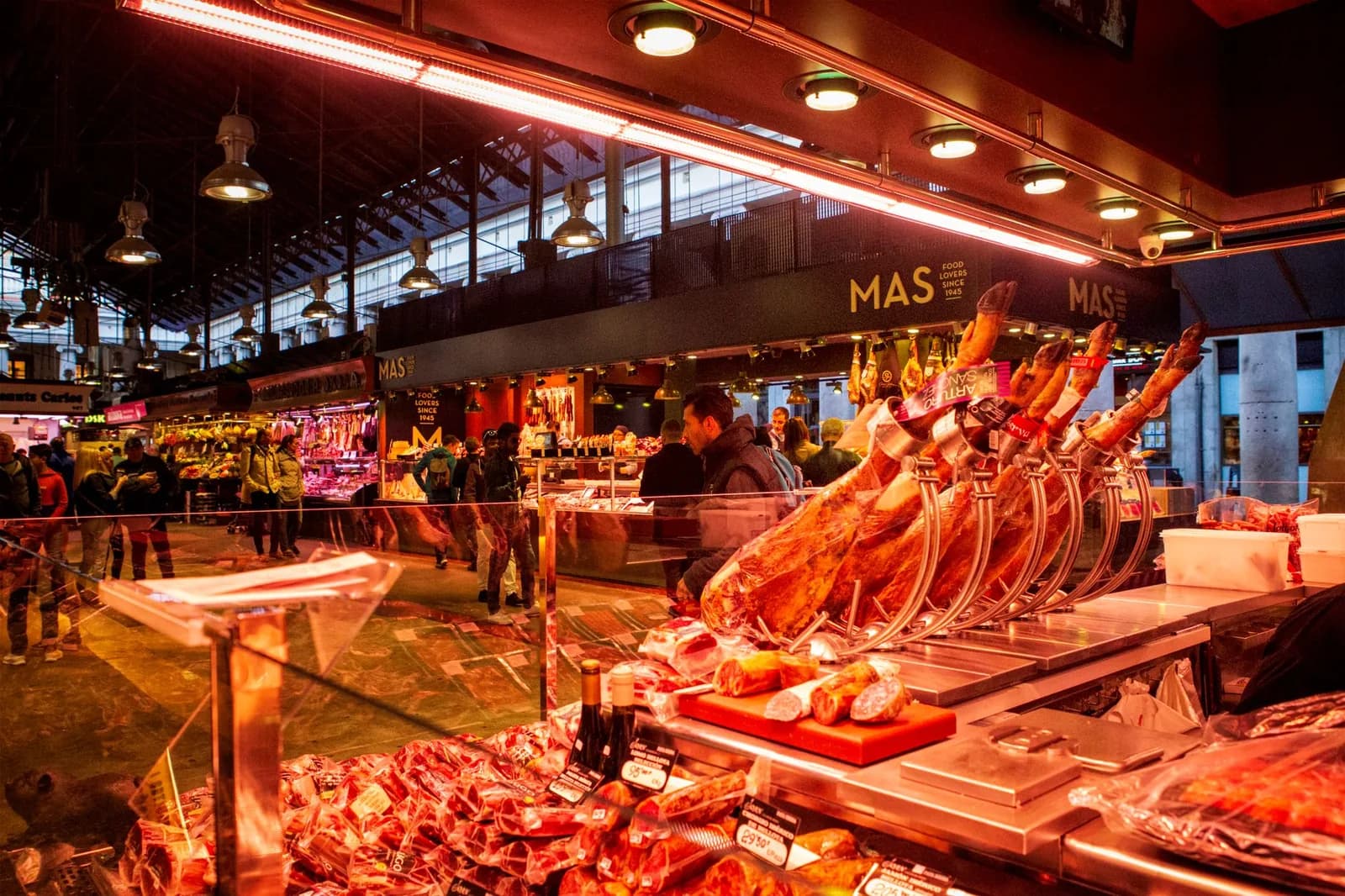 Étal de jambon et de produits frais dans un marché couvert espagnol
